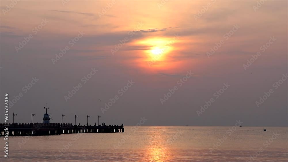 A bridge extending into the sea on the beach at sunrise A bridge extending into the sea on the beach at sunrise
