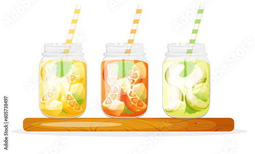 Soft drinks in glass jar with lemon, orange and apple standing on the wooden cutting board.