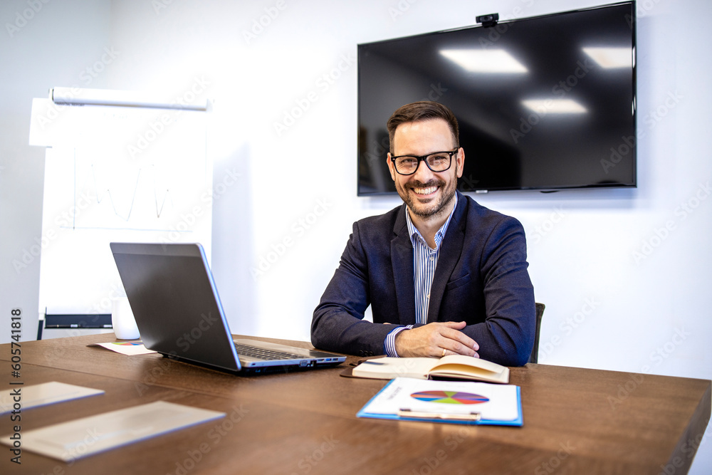 Portrait of company manager in business suit sitting in his working office. Portrait of company manager in business suit sitting in his working office.