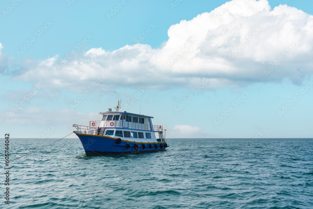 Obraz premium Ferry boat sailing on blue sea ripples