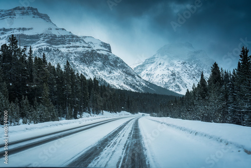 Scenic road trip with snowy pine forest and rocky mountains in gloomy day © Mumemories