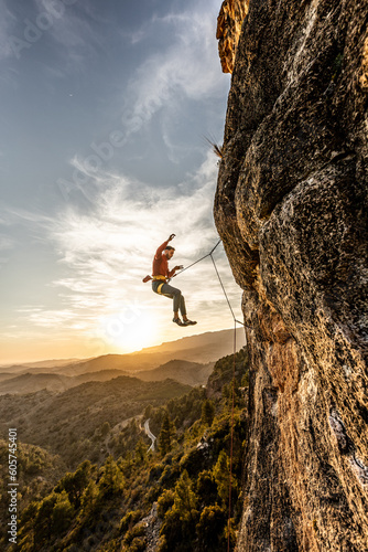 man climbing at sunset on a trip, fearless courageous person, fearless person, extreme sport confidence dramatic sky, sport professional mountain safety, risk of accidents