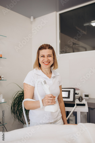 Portrait of happy dermatologist, skin therapist, beautician and skincare professional in workplace. Smiling beautiful young woman in white uniform