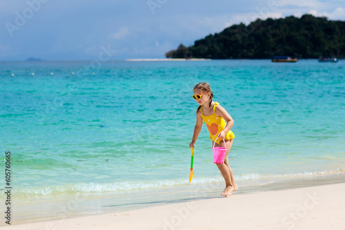 Kids play on tropical beach. Sand and water toy.