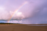 rainbow and pink skies on beach