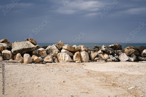 stone breakwater and dramatic sky before storm