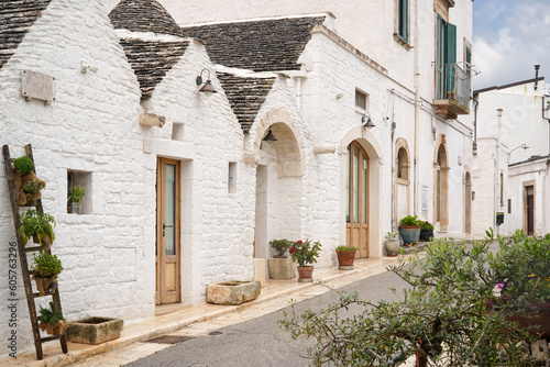 Fototapeta Naklejka Na Ścianę i Meble -  one of the street decorated with flowers in Alberobello -touristic famous town known from the trulli unique houses, Apulia, Italy