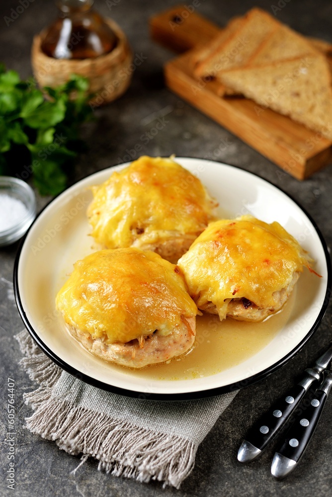 Chicken cutlets baked with cheese, mushrooms and potatoes