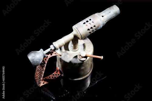 old and vintage blow torch isolated on black background