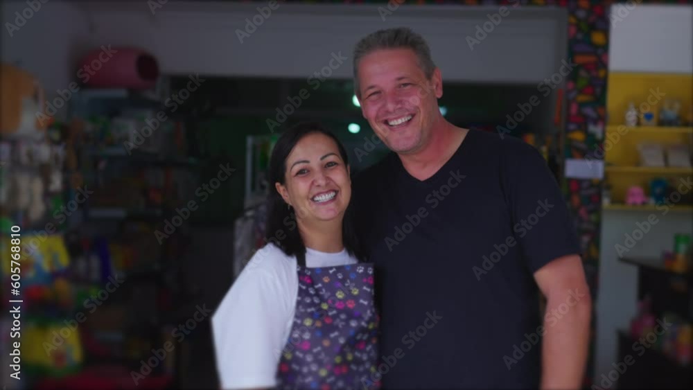 Authentic joyful couple owners of Small Local Business posing for camera smiling. Brazilian Entrepreneurs of Pet Shop in storefront Authentic joyful couple owners of Small Local Business posing for camera smiling. Brazilian Entrepreneurs of Pet Shop in storefront