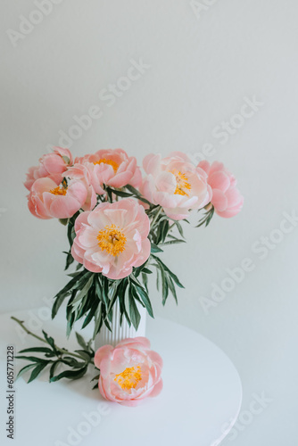 Fototapeta Naklejka Na Ścianę i Meble -  a bouquet of delicate peonies on a white round table in the interior isolated 