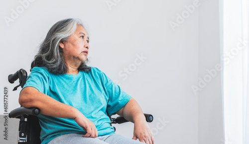 Asian elderly woman patient sat on wheelchair, which she is saddened from depression. to elderly and health care Our Minds Matter concept.