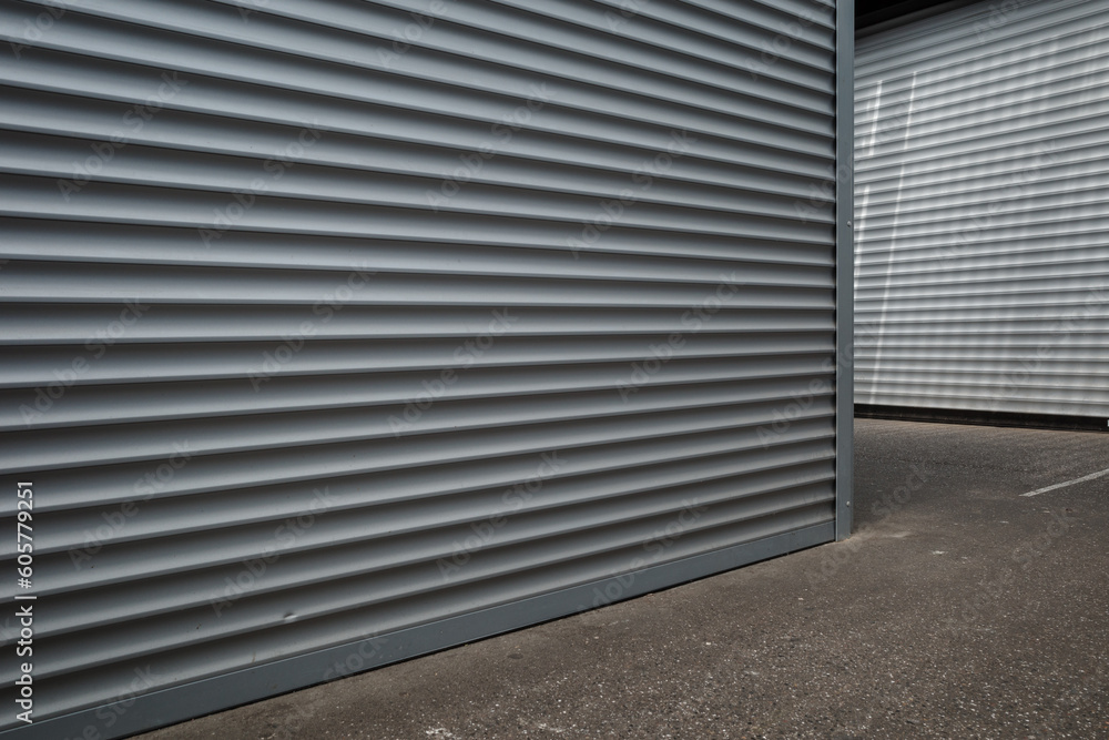 Low angle and exterior view in front of closed storefront, and closed roller shutter door, at the closed market. Low angle and exterior view in front of closed storefront, and closed roller shutter door, at the closed market.