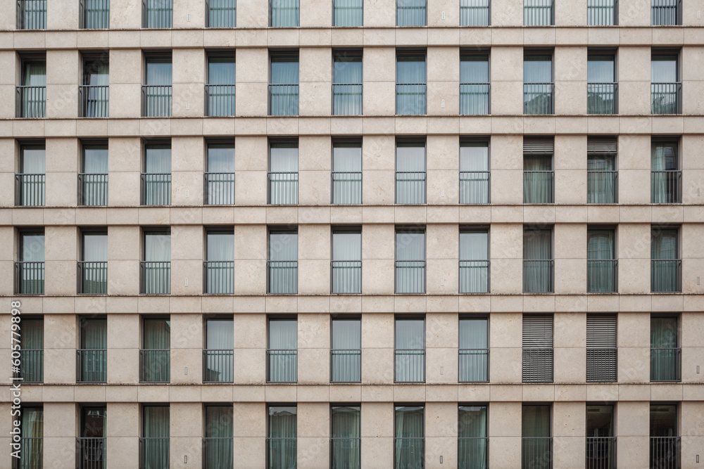Outdoor exterior front view of modern facade with typical rectangular windows with reflection glass and randomly opening curtains. Outdoor exterior front view of modern facade with typical rectangular windows with reflection glass and randomly opening curtains.