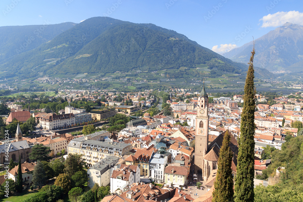 The spire of the church St. Nikolaus and Merano panorama with mountains, South Tyrol, Italy
