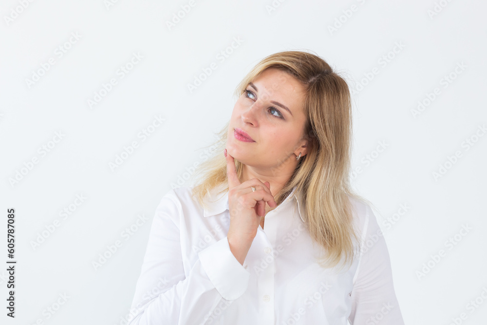 Pretty portrait of young beautiful woman thinking looking left and smiling a bit having a finger at chin isolated on white background Pretty portrait of young beautiful woman thinking looking left and smiling a bit having a finger at chin isolated on white background
