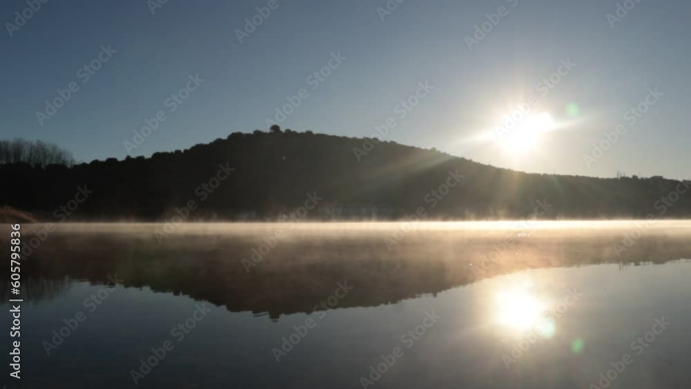 fog over the lake early with sunrise and sun in the corner
fog over the lake early with sunrise and sun in the corner