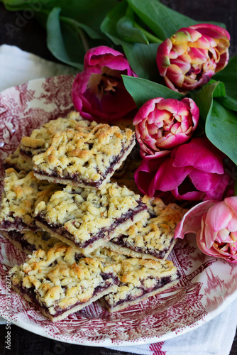 Streusel pie with currant and rose petal filling on a background of tulips.