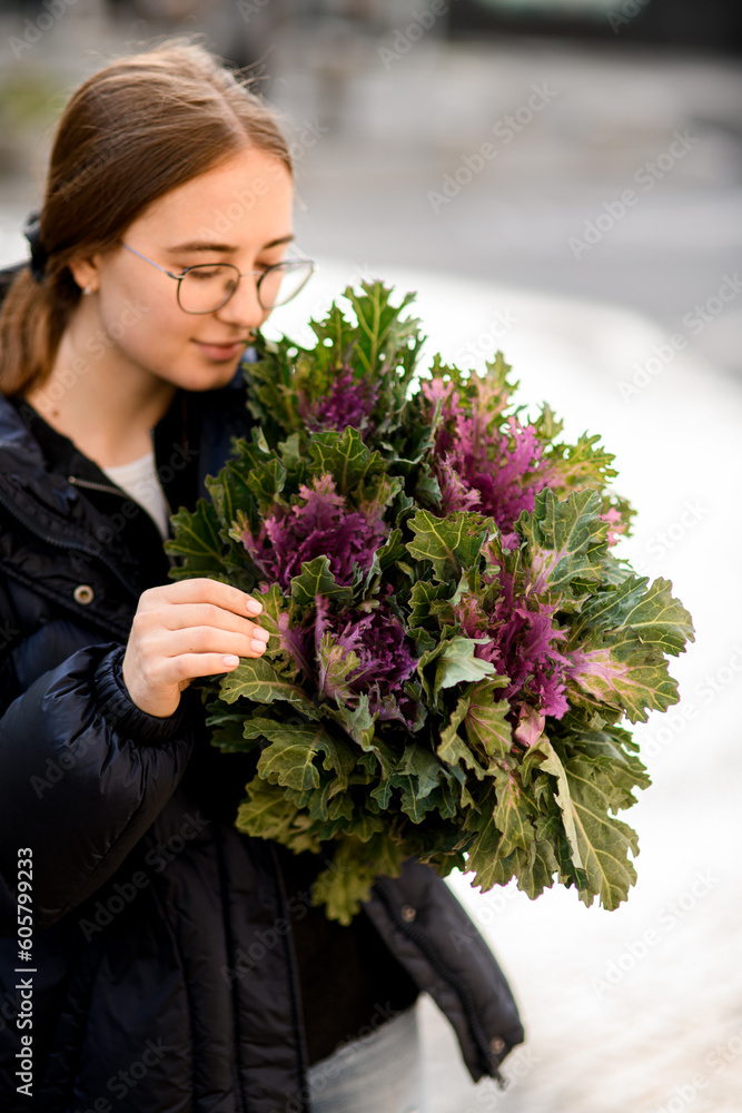 Fototapeta premium Girl florist holding big and beautiful mono bouquet of fresh decorative brassica cabbage