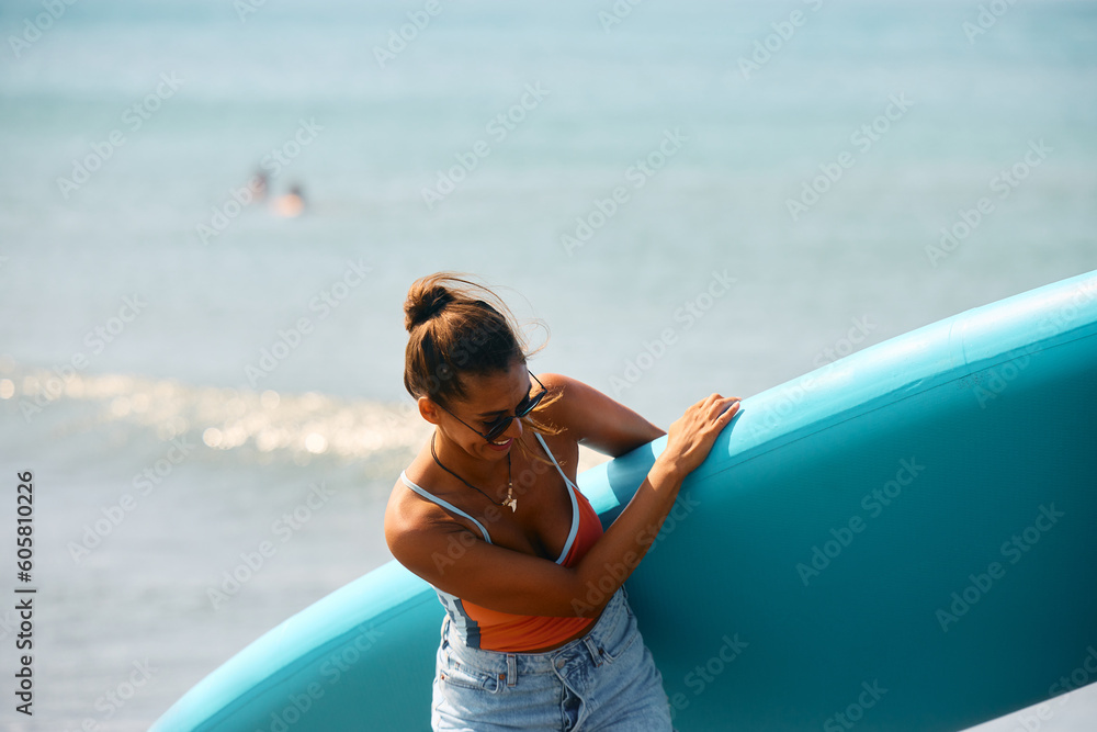 Cheerful female surfer has fun on beach.