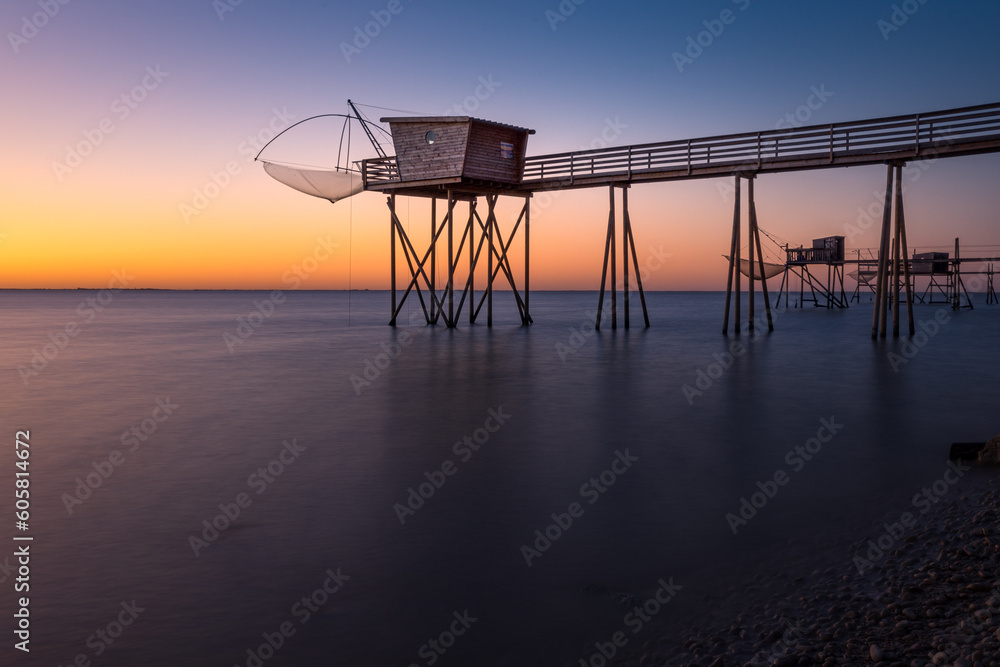 Fishing hut on stilts coast of Atlantic ocean at sunset near La Rochelle, Charente Maritime, France Fishing hut on stilts coast of Atlantic ocean at sunset near La Rochelle, Charente Maritime, France