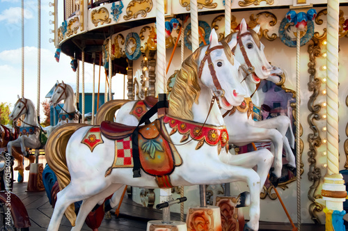 A carousel with beautiful white horses. Festival