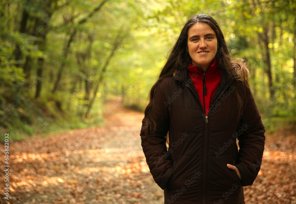 Trekking lover, adventurer woman posing in front of a green blurry background in the forest. Copy space for text, advertising, message Trekking lover, adventurer woman posing in front of a green blurry background in the forest. Copy space for text, advertising, message