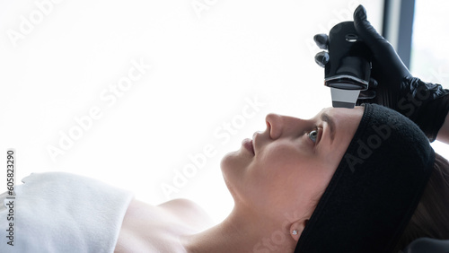 Woman on ultrasonic cleaning procedure. Hardware cosmetology. 