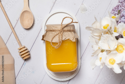 Jar with honey and flowers on wooden background top view, flat lay