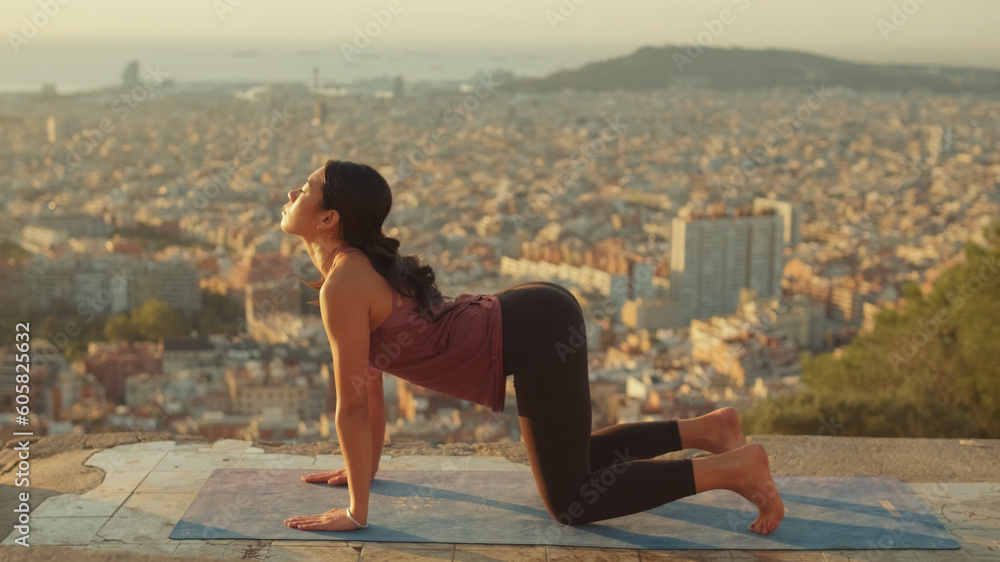 Girl is stretching, practicing yoga on the observation deck