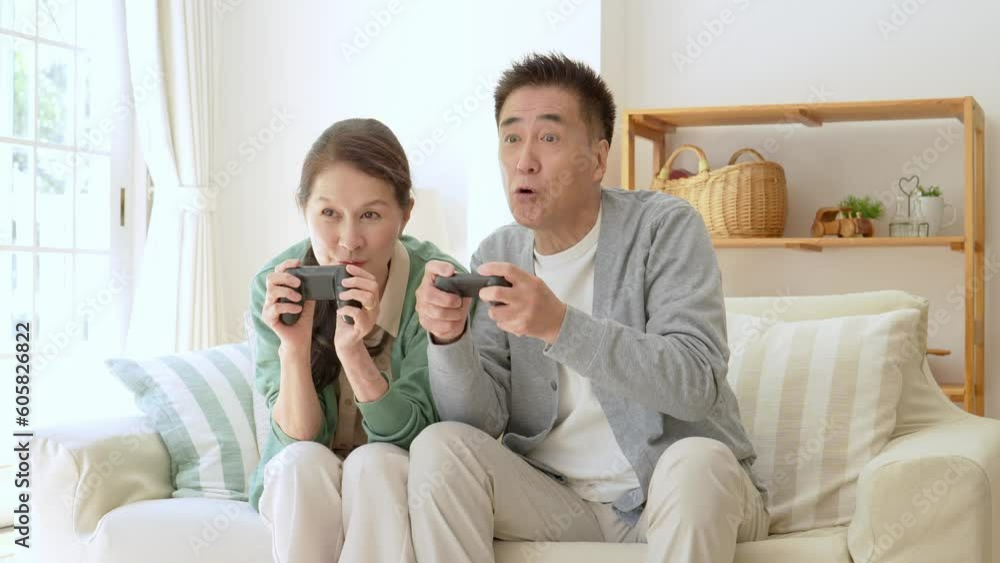 リビングでテレビゲームを楽しむシニア夫婦 リビングでテレビゲームを楽しむシニア夫婦