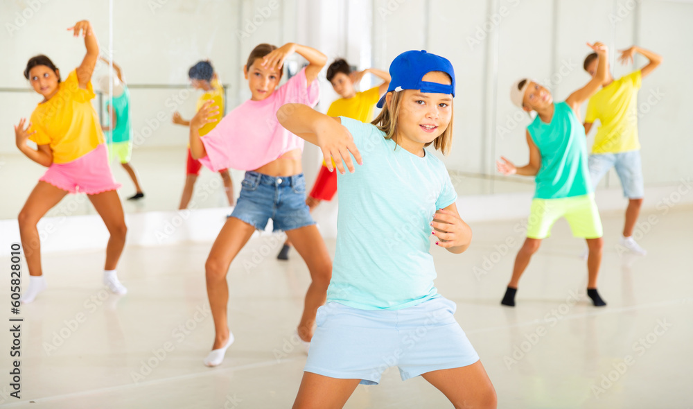 Active children dancing modern dances in a choreographic studio