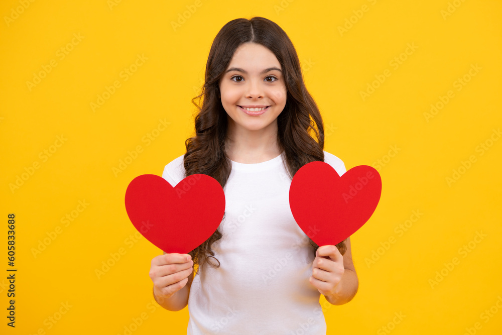 Lovely romantic teenage girl hold red heart symbol of love for valentines day isolated on yellow background. Happy teenager, positive and smiling emotions of teen girl. Lovely romantic teenage girl hold red heart symbol of love for valentines day isolated on yellow background. Happy teenager, positive and smiling emotions of teen girl.
