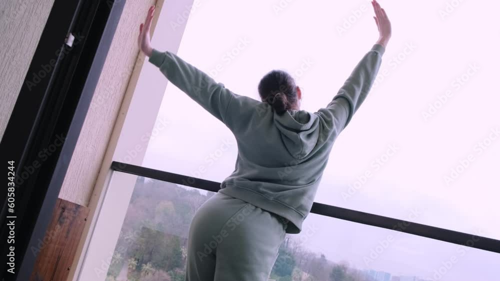 Beautiful girl in a tracksuit on the balcony of a hotel room. Back view. Stretches out his hands and enjoys the fresh air
Beautiful girl in a tracksuit on the balcony of a hotel room. Back view. Stretches out his hands and enjoys the fresh air