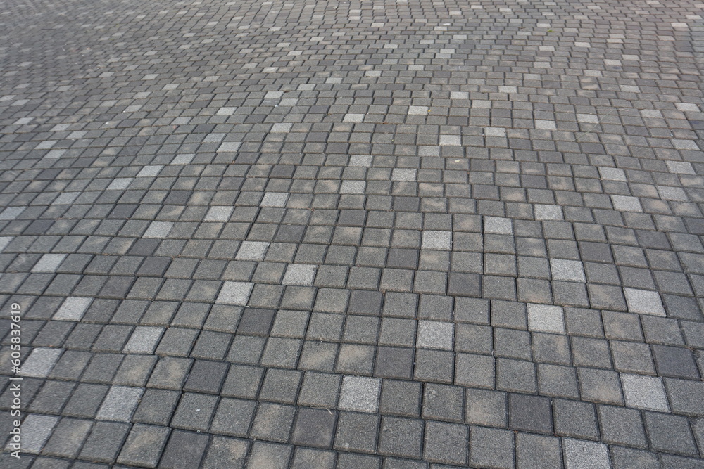 Pavement walkway made with grey, black and white colors stone, with wavy pattern background texture