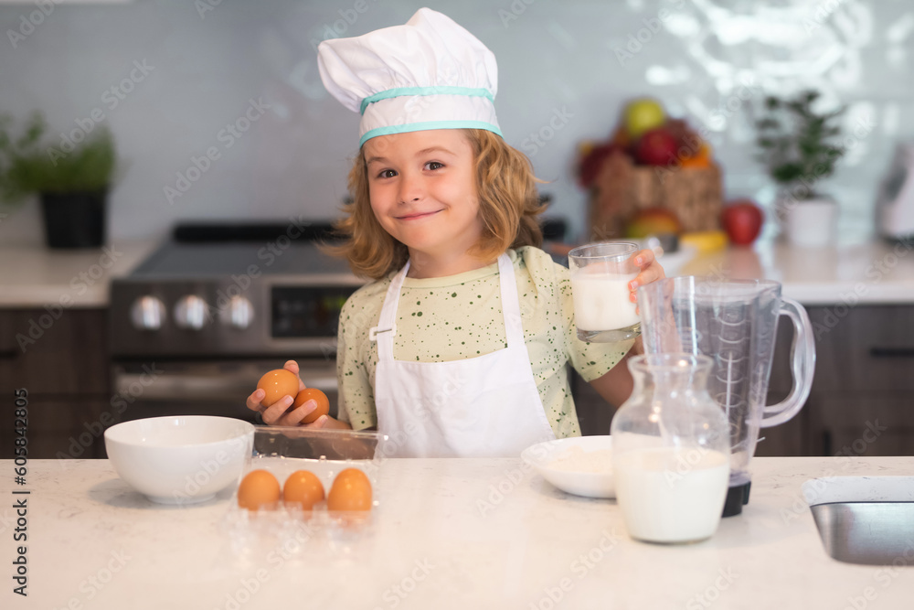 Funny kid with eggs at kitchen. Kid chef cook cookery at kitchen. Cute boy cooking in kitchen at home kitchen. Healthy ingredients. Portrait of little child in uniform of cook. Cute child to be chef. Funny kid with eggs at kitchen. Kid chef cook cookery at kitchen. Cute boy cooking in kitchen at home kitchen. Healthy ingredients. Portrait of little child in uniform of cook. Cute child to be chef.