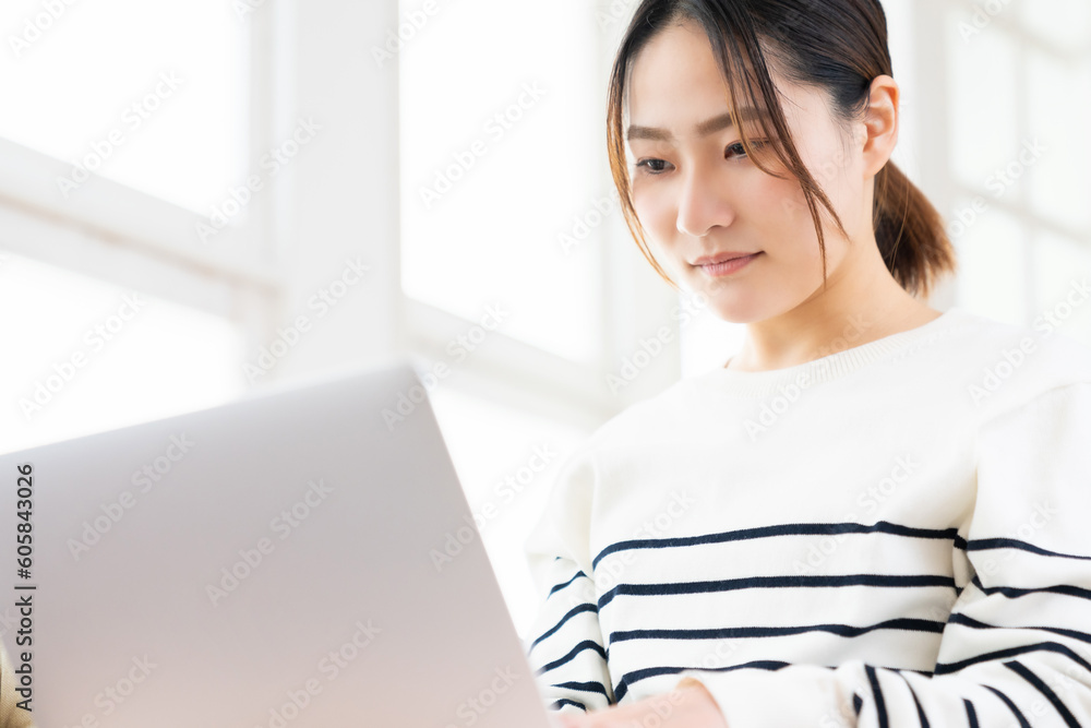 部屋でラップトップコンピューターを見る女性 部屋でラップトップコンピューターを見る女性