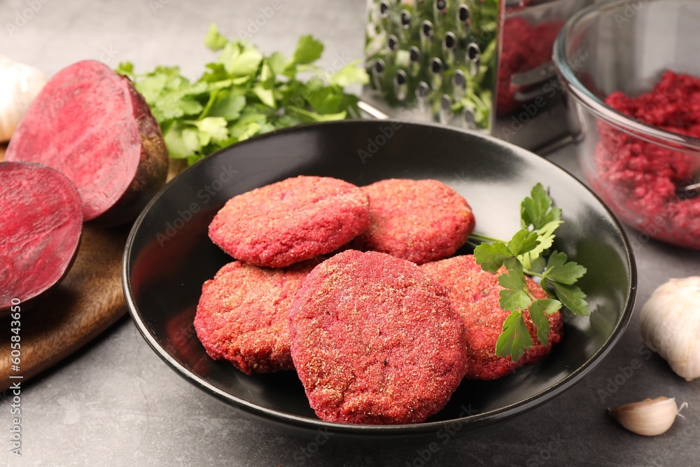 Delicious beetroot cutlets and parsley in black bowl on light gray table. Vegan dish Delicious beetroot cutlets and parsley in black bowl on light gray table. Vegan dish