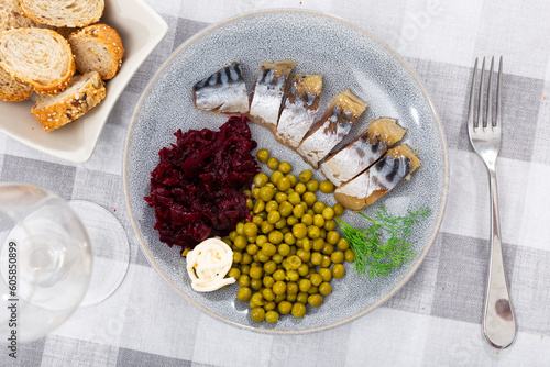 Delicate cold smoked mackerel with grated boiled beets, mayonnaise and canned peas. Decorated with a sprig of dill