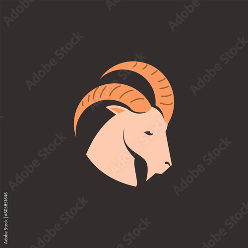 A goat head with a big horns on a dark background.
