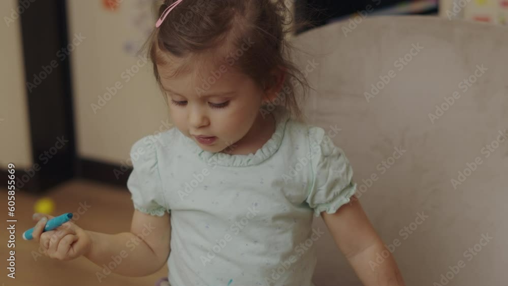 Portrait of cute little drawing with markers sitting on the floor at home, playing, having fun in the weekends. Blue art paint. Playing child. Portrait of cute little drawing with markers sitting on the floor at home, playing, having fun in the weekends. Blue art paint. Playing child.