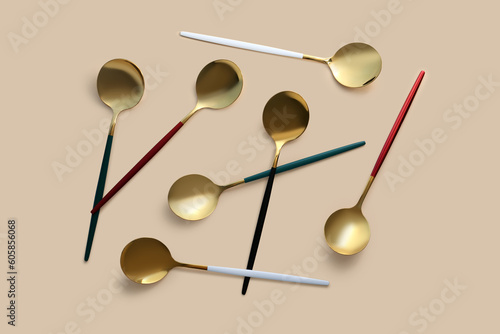 Golden spoons on beige background