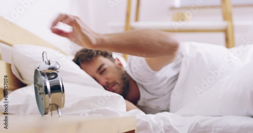 Alarm, clock and wake up, man in bed sleeping for rest or refresh in morning, getting ready for start of day in apartment. Sleep, dream and person waking in bedroom after snooze or nap time in home.