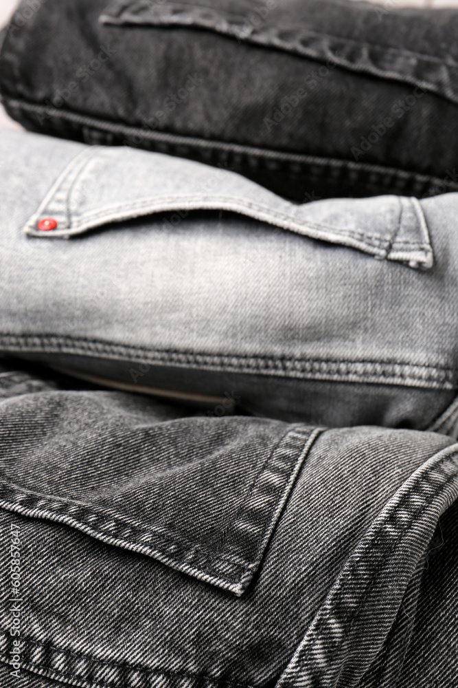 Different folded denim jeans as background, closeup