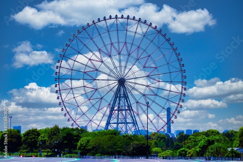 A ferris wheel at the park behind the blue sky