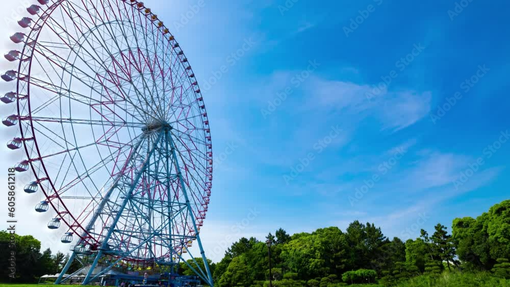 A timelapse of moving ferris wheel at the park behind the blue sky wide shot zoom A timelapse of moving ferris wheel at the park behind the blue sky wide shot zoom