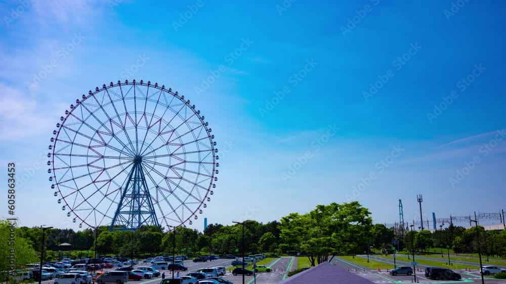 A timelapse of moving ferris wheel at the park behind the blue sky wide shot A timelapse of moving ferris wheel at the park behind the blue sky wide shot