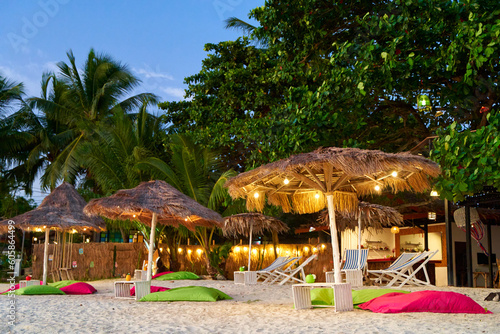 Beach umbrella made of dried palm fronds on a tropical island beach. A luxurious vacation concept