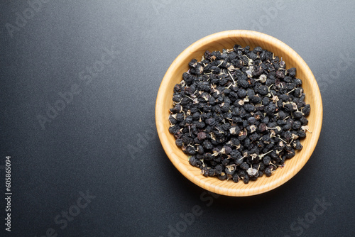 black Chinese wolfberry in a wooden bowl. top view.
