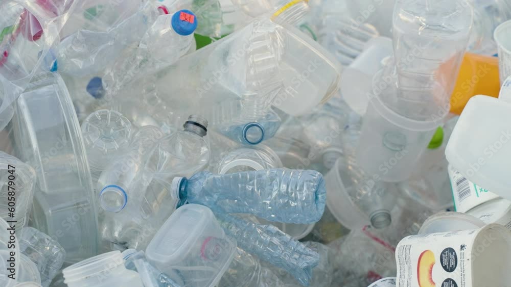 A pile of plastic water bottles, containers and other recyclable items. A pile of plastic water bottles, containers and other recyclable items.